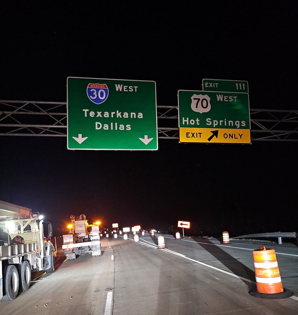 Overnight crew installing overhead interstate exit signs on I-30
