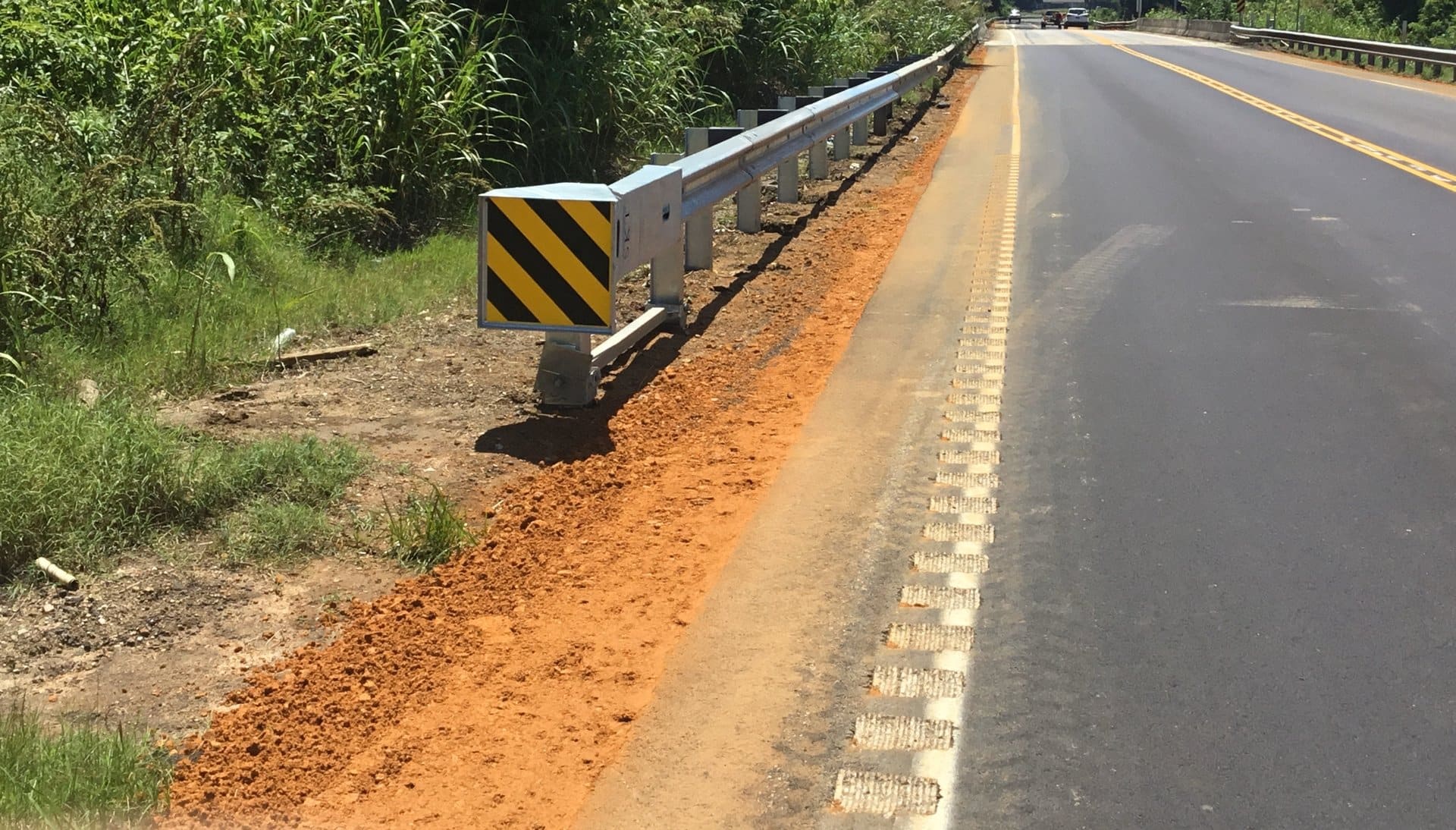 W-beam guardrail with striped object marker along a rural two-lane road